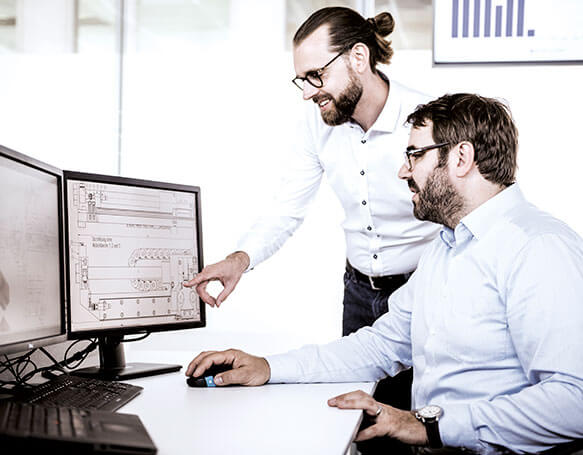 Zwei Mitarbeiter in der IT schauen auf einen Bildschirm